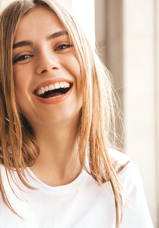 Portrait of beautiful smiling blond model dressed in summer hipster clothes. Trendy girl posing in the street background. Funny and positive woman having fun